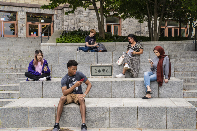 Students sitting and viewing phones