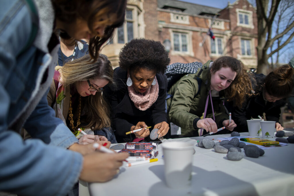 students writing notes at a Penn outdoor event